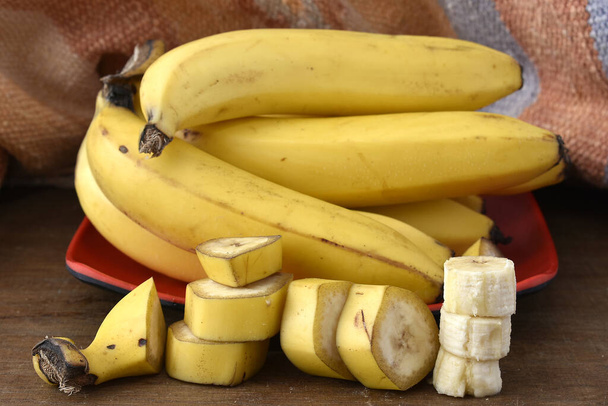 куча бананов на деревянном столе - Фото, изображение