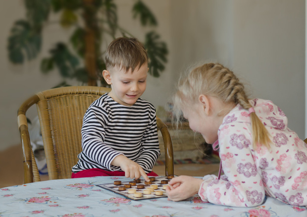 Young girl and boy playing checkers together - Foto, Imagen