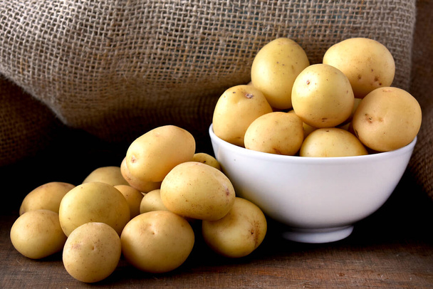 syrové brambory v pytli na dřevěném stole - Fotografie, Obrázek