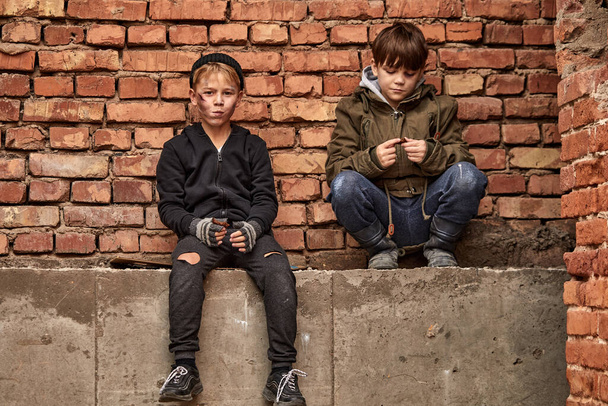 two friendly street boys sharing piece of bread, eating together - Fotografie, Obrázek