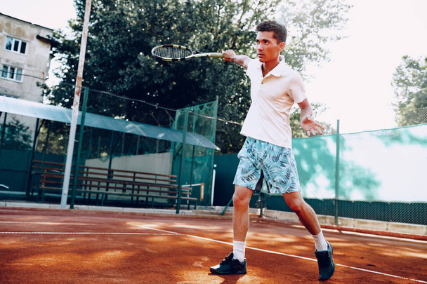 Fit man plays tennis on tennis field - Фото, зображення