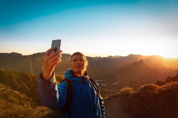счастливый турист делает селфи в горах, путешествуя на природе - Фото, изображение