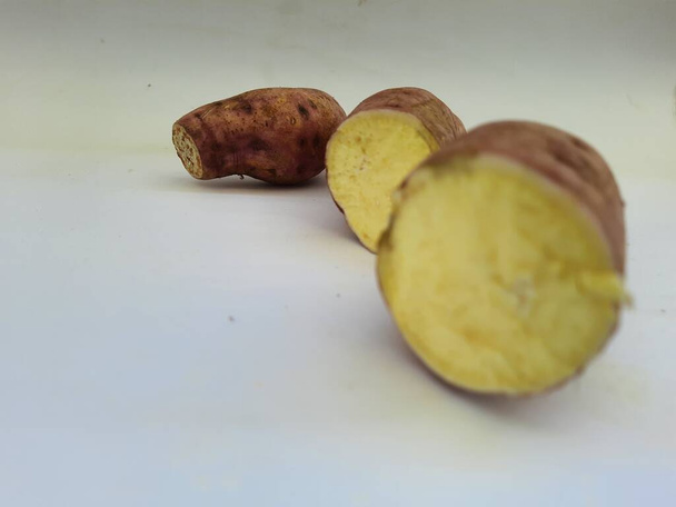 Dışı pembe ve içi sarı renkli tatlı patates yığını beyaz arkaplanda izole edilmiş. - Fotoğraf, Görsel