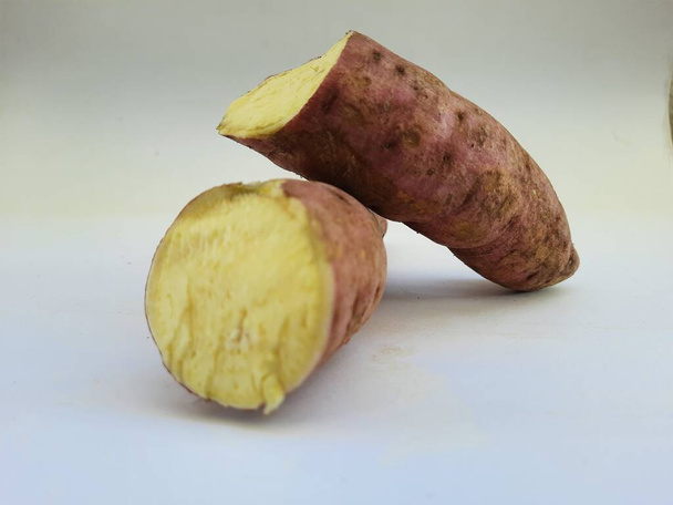 Dışı pembe ve içi sarı renkli tatlı patates yığını beyaz arkaplanda izole edilmiş. - Fotoğraf, Görsel