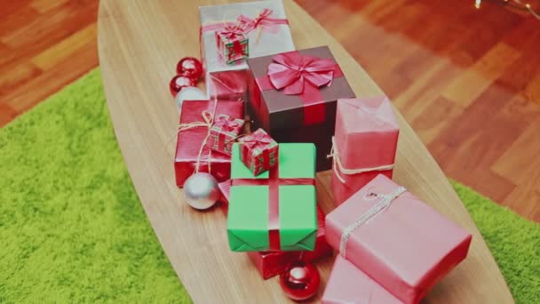 Horní pohled uzavírá vánoční dárkové krabice na stole a světla ozdoby Vánoce slaví nový rok v obývacím pokoji doma. Koncept Vánoční oslavy. - Záběry, video