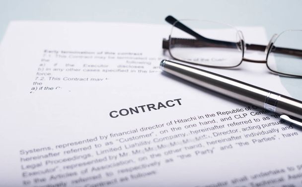 Contract or agreement with pen and eyeglasses on office table. Close up. Concept of concluding - Φωτογραφία, εικόνα