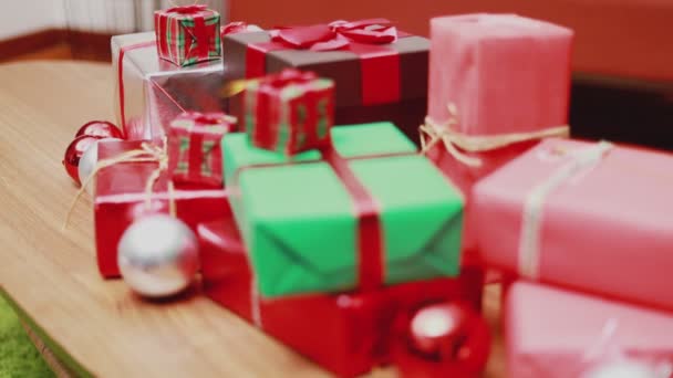 Κλείστε μέχρι χριστουγεννιάτικο κουτί δώρου στο τραπέζι και τα φώτα στολίδια Χριστούγεννα γιορτάζει το νέο έτος στο σαλόνι στο σπίτι. Χριστουγεννιάτικη γιορτή. - Πλάνα, βίντεο