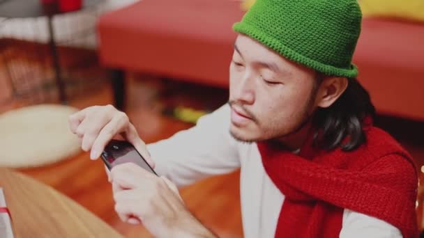 Zblízka asijské muži brát foto dárkové krabice na smartphone zdobí vánoční stromeček slaví nový rok v obývacím pokoji doma. Koncept Vánoční oslavy. - Záběry, video
