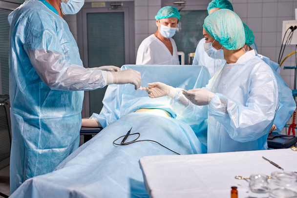 team of professional smart serious surgeons wearing medical uniform had difficult operation - 写真・画像