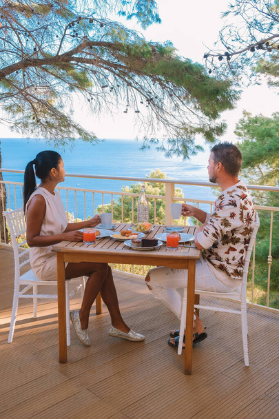 シチリアの丘を見渡す庭で朝食を持っているカップル,朝食を持って休暇で中年の男性と女性 - 写真・画像