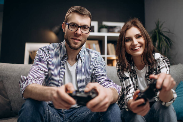 Χαρούμενος άντρας και γυναίκα που παίζουν παιχνίδια στο σπίτι - Φωτογραφία, εικόνα