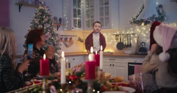 Pieni poika esittämässä runoa perheelle jouluaterialla - Materiaali, video