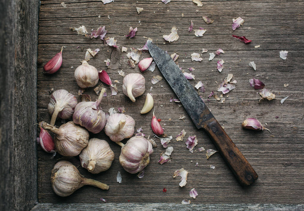 Garlic in burlap. Peeled garlic cloves, garlic bulb on a dark background. Healthy eating concept. Blurred background. - Photo, Image