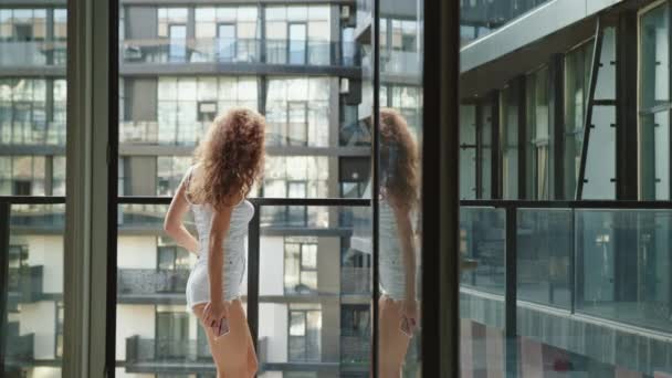 A young beautiful woman is dancing on the balcony. She is listening to music. 4K - Footage, Video