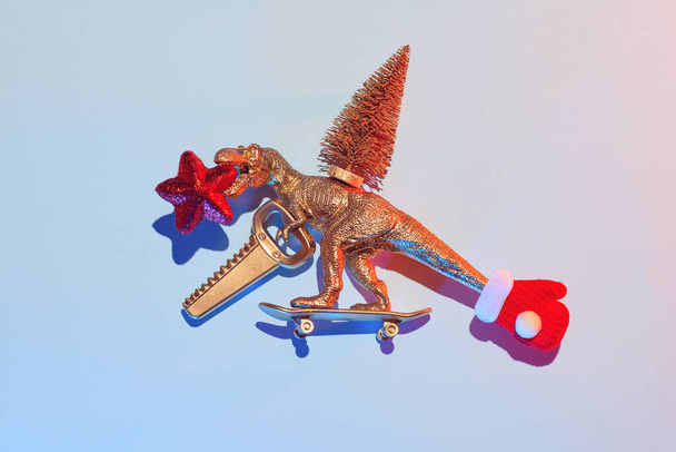 New Year's story of how a golden dinosaur stole a Christmas tree with a saw and a star on a skateboard, a Christmas concept - Φωτογραφία, εικόνα
