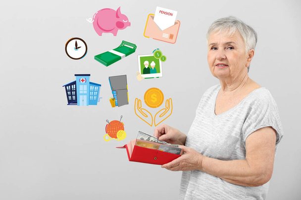 Elderly woman with wallet planing her budget on grey background - Foto, Imagen