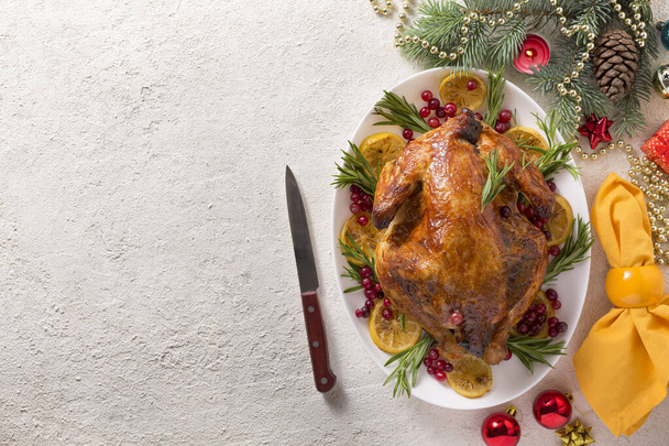 Χριστουγεννιάτικο τραπέζι με ψητό κοτόπουλο είναι γιορτινά διακοσμημένο με κεριά. - Φωτογραφία, εικόνα