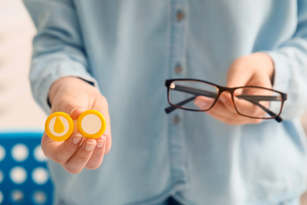 Женщина с очками и футляром для контактных линз в клинике - Фото, изображение