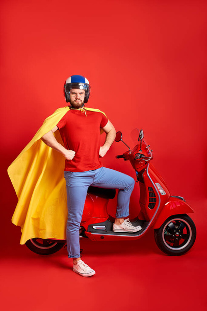 strong super hero man in cloak stand next to motorcycle - Zdjęcie, obraz