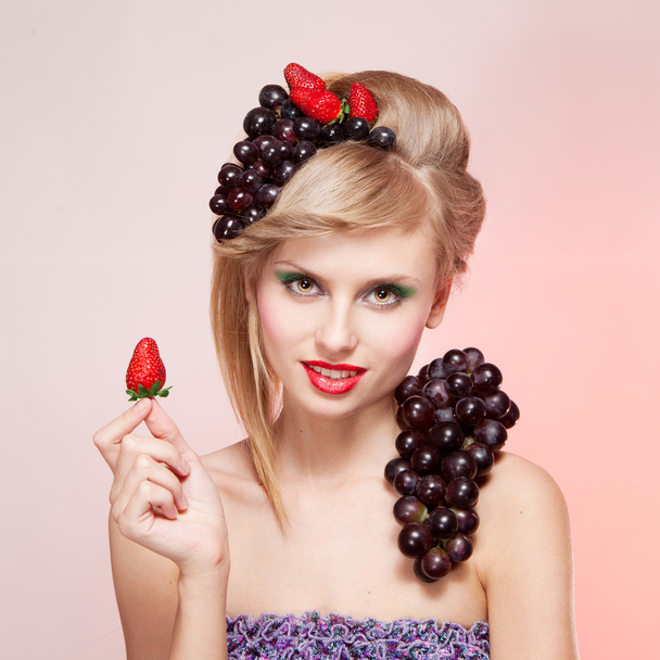 Woman with strawberry and bunch of grapes - Φωτογραφία, εικόνα
