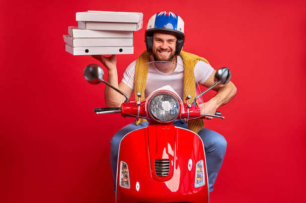nice caucasian male guy driving moped motorcycle bringing pile stack pizza order - Foto, Imagem