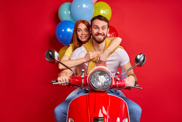 nice beautiful couple on motorcycle bringing carrying bunch air balls festive decoration isolated - Fotó, kép