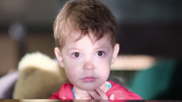 little boy sits at a table in a cafe and waits for a treat. close up view. Slow motion video. stock footage - Footage, Video