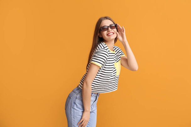 Szczęśliwa kobieta w stylowych okularach przeciwsłonecznych na tle koloru - Zdjęcie, obraz