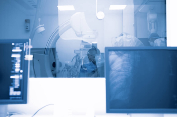 Chirurgisch onderzoek van de patiënt, uitgevoerd onder röntgencontrole met behulp van digitale apparatuur door een groep artsen. - Foto, afbeelding