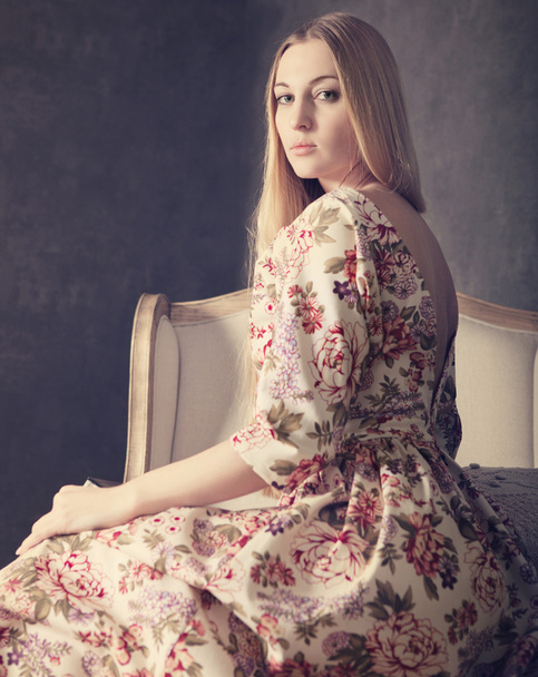 Menina loira bonita em vestido longo na sala de estar
 - Foto, Imagem