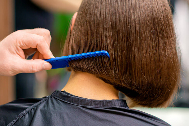 Widok z tyłu męski fryzjer czesanie krótkie włosy kobiety w salonie - Zdjęcie, obraz
