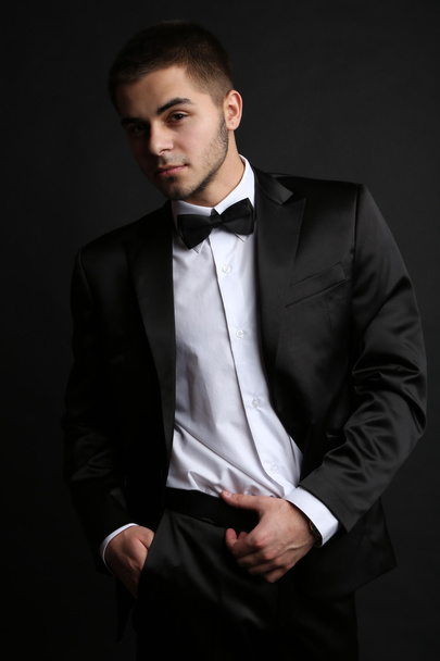 Handsome young man in suit on dark background - Photo, image
