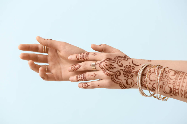 Beautiful female hands with henna tattoo on light background - Photo, Image