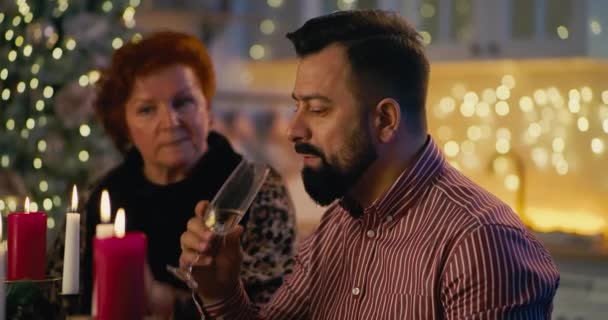 Egy férfi családi beszélgetéssel a karácsonyi vacsorán - Felvétel, videó