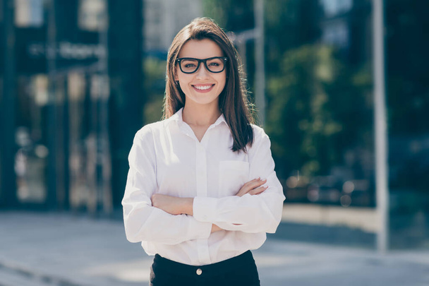 Photo of charming smiling young lady dressed white formal shirt glasses hands arms crossed outside - Foto, immagini