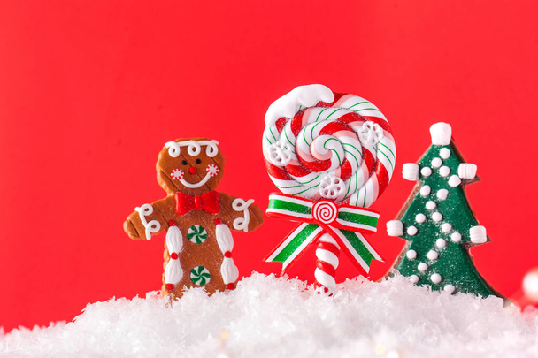 Christmas Lollipop, Christmas tree, ginger man in the snow on a red background. Copy space. Christmas background. - Фото, зображення