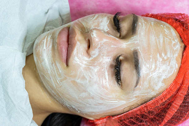 Face descascamento máscara, tratamento de beleza spa, cuidados com a pele. Mulher recebendo cuidados faciais por esteticista no salão de spa, vista lateral, close-up - Foto, Imagem