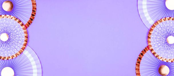 Backgrop monocromo con abanicos de papel violeta y dorado sobre gris sólido - Foto, imagen