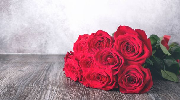 Red rose flowers bouquet on shelf in front of stone wall - Image - Foto, immagini