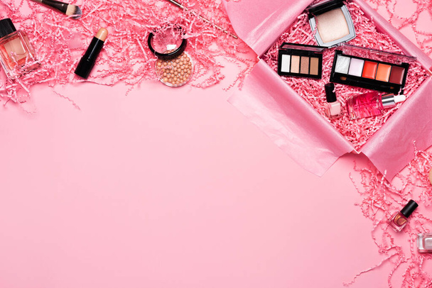 Beauty box with makeup cosmetics filled with shredded pink paper - Foto, immagini