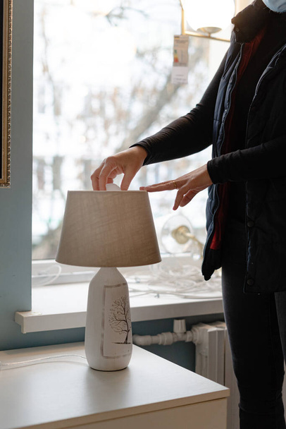Woman hand replacing light bulb for energy saving one. Energy efficiency at home - Valokuva, kuva