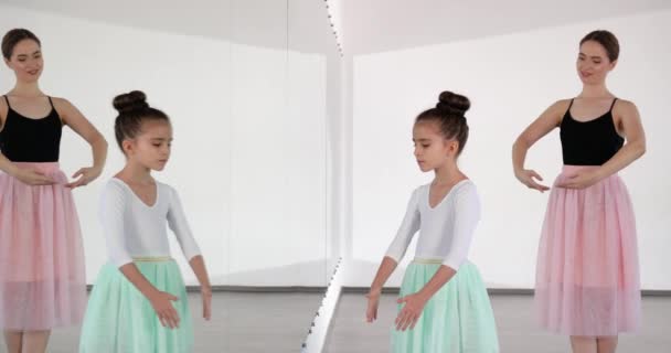 Маленькая балерина тренируется с тренером в танцевальной студии - Кадры, видео