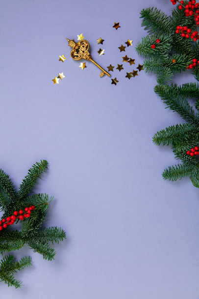 Golden key and Christmas tree branches with bunches of rowan on background - Foto, Imagen