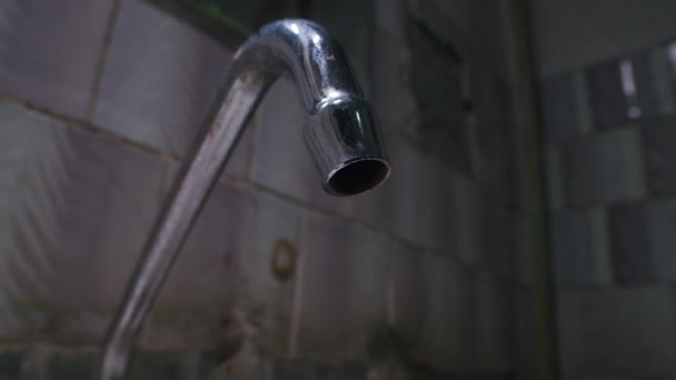 Zeitlupenaufnahmen von tropfendem Wasser aus dem Wasserhahn im armen Badezimmer - Filmmaterial, Video