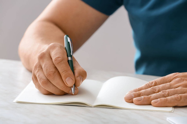 Muž psaní v notebooku s perem - Fotografie, Obrázek