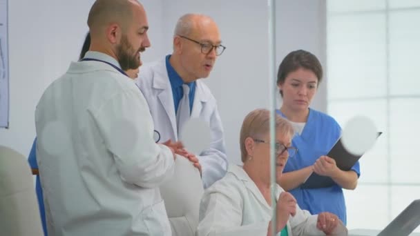 Ärzteteam steht mit Laptop im Konferenzkrankenhauszimmer - Filmmaterial, Video