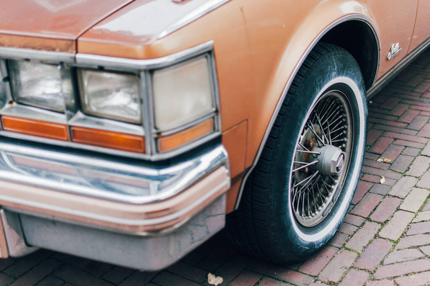 Wheel and car light of a Cadillac Seville 1975 car in the streets of Zaanse Schans. Brick floor. - Foto, afbeelding