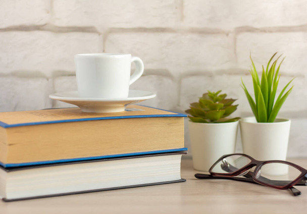 Una pequeña taza de café de la mañana y un libro sobre la mesa. - Foto, imagen