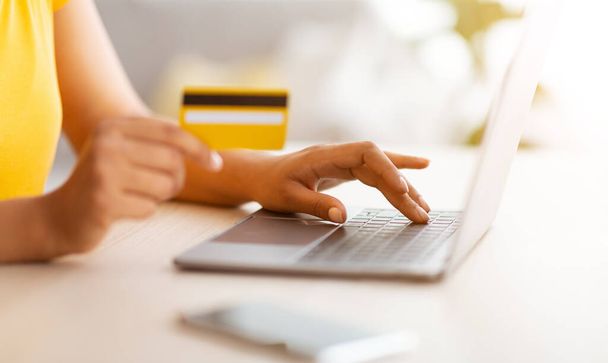 Nero signora utilizzando laptop e carta di credito di debito a casa - Foto, immagini