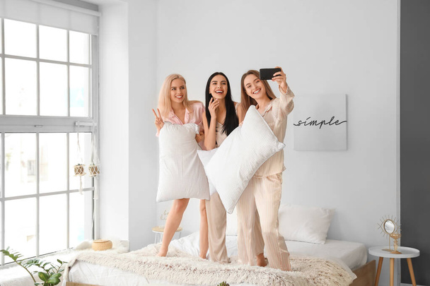 piękne młode kobiety biorąc selfie na piżama party - Zdjęcie, obraz